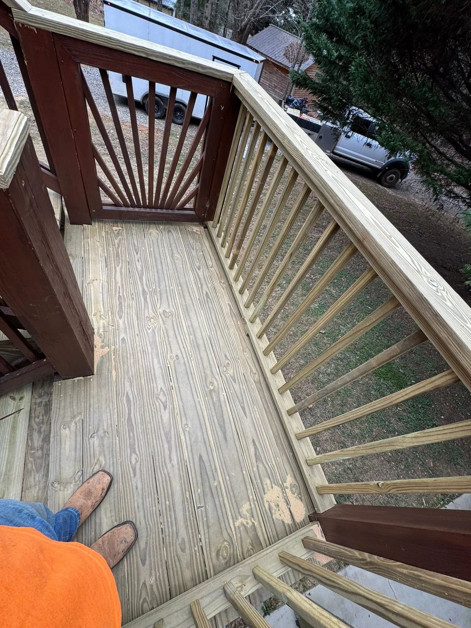 Multi-level deck with sunburst railing, pressure-treated decking, and wooden stairs