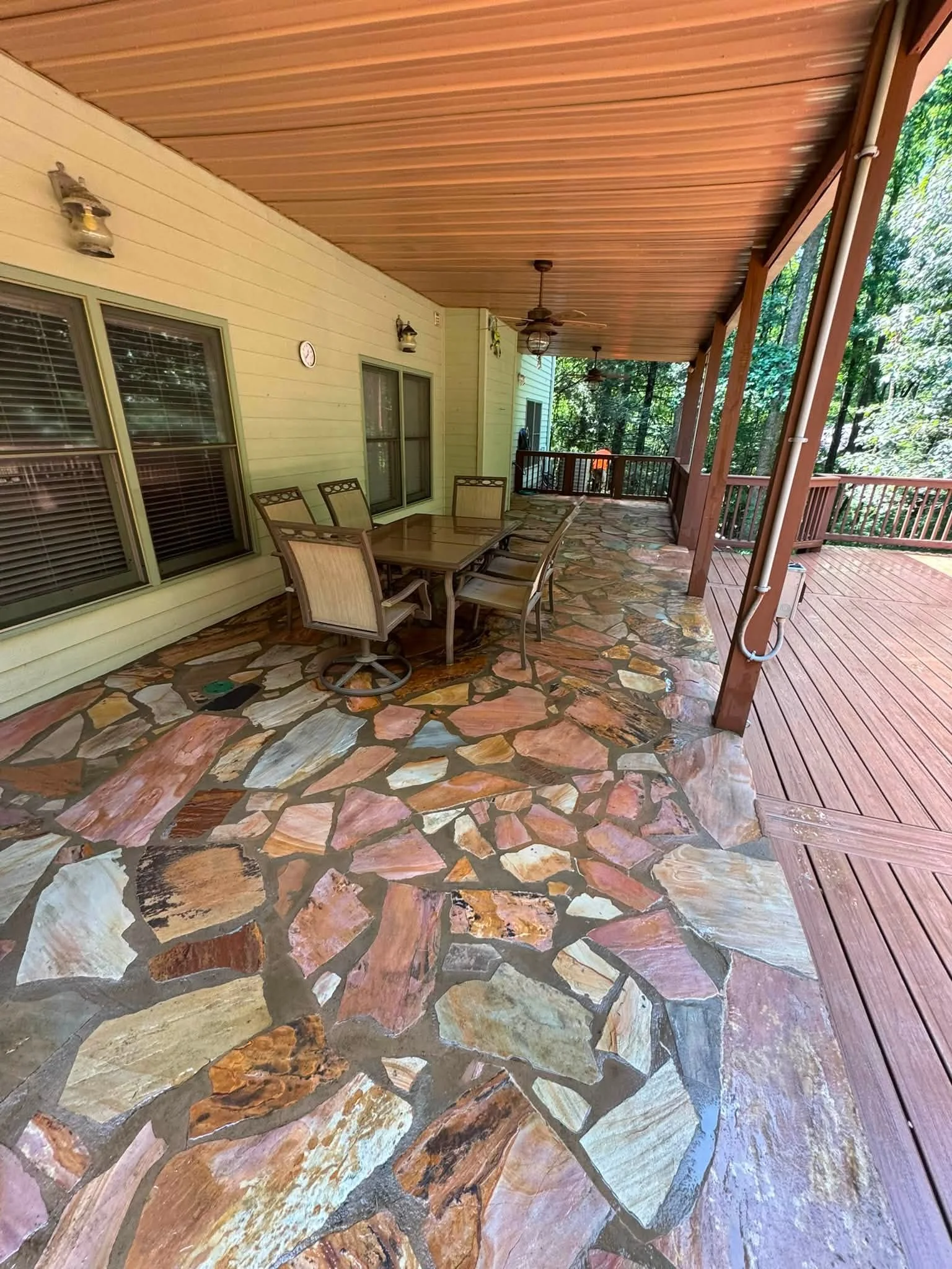 Flagstone patio with cedar pergola ceiling and composite deck extension