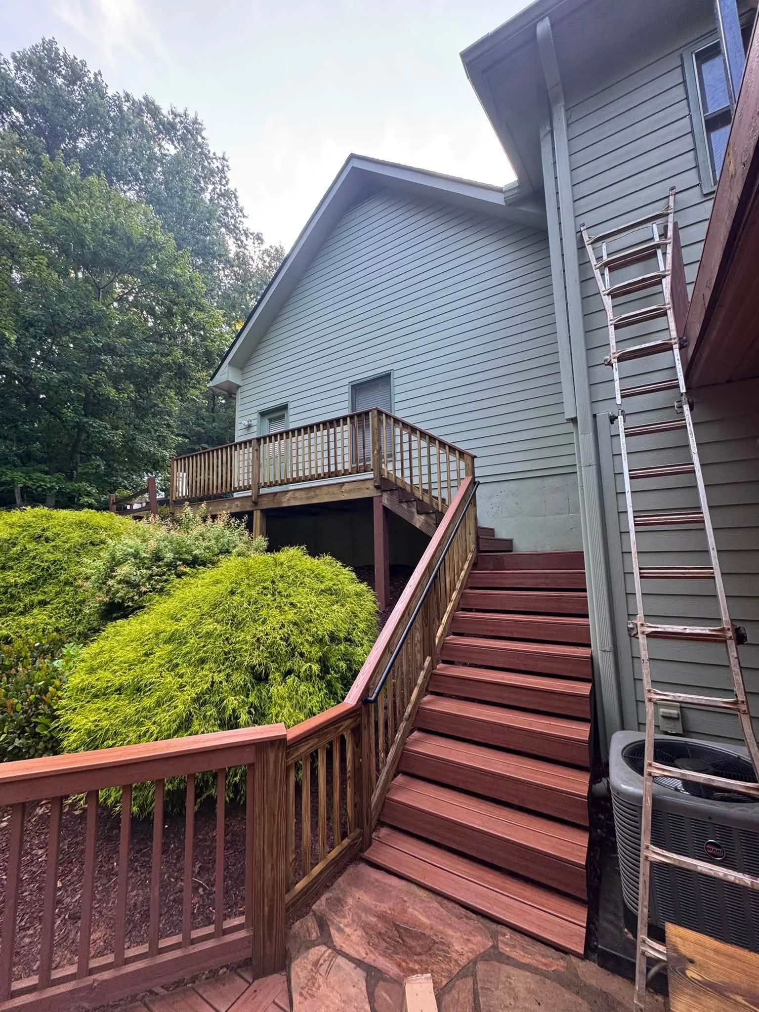 Multi-level deck with burgundy stairs and railings, composite decking, vertical balusters