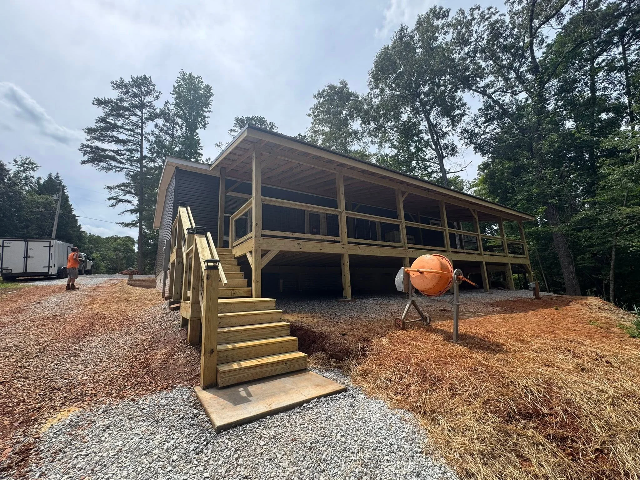 Elevated wooden deck with screened porch, pressure-treated framing, and full staircase
