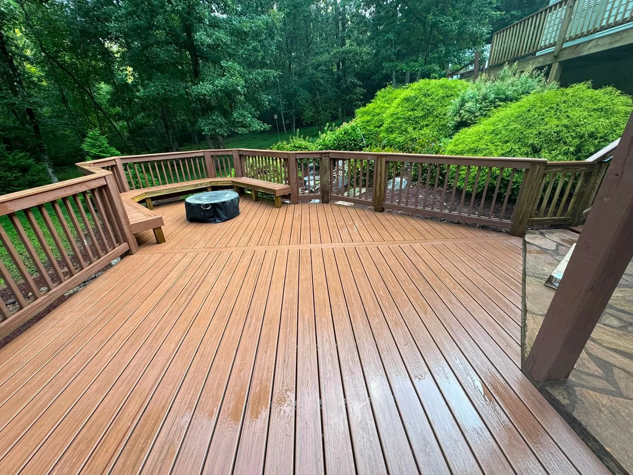 Composite deck with curved railings, bench seating, and lattice panels overlooking landscaped yard